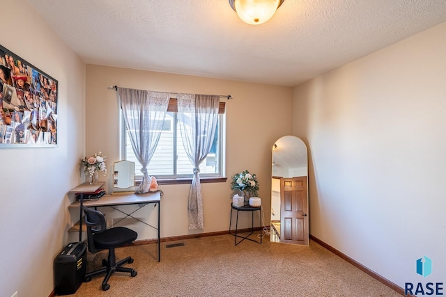 office with baseboards, carpet floors, a textured ceiling, and visible vents