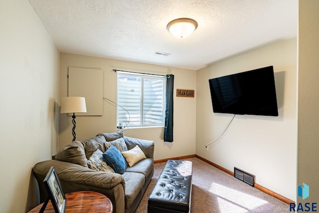 living room with visible vents, carpet floors, a textured ceiling, and baseboards