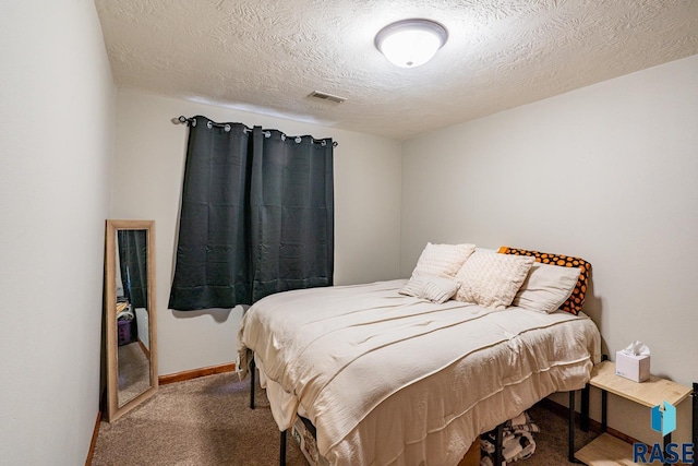 carpeted bedroom with visible vents, baseboards, and a textured ceiling