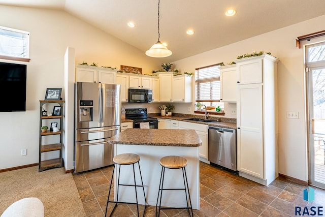 kitchen with black appliances, a sink, plenty of natural light, a center island, and white cabinetry