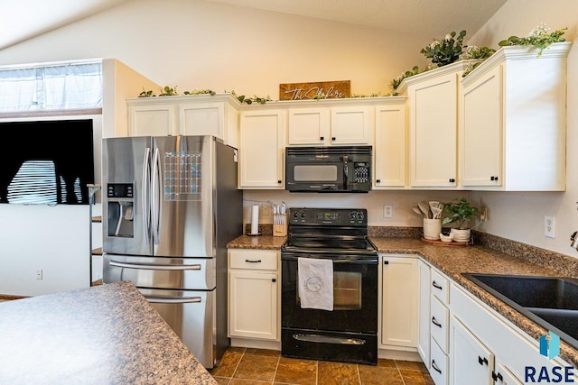 kitchen with a sink, black appliances, white cabinets, and vaulted ceiling