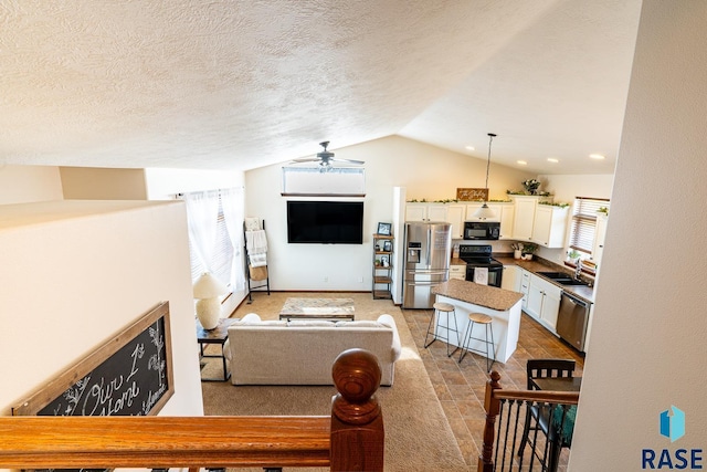 living room featuring baseboards, a textured ceiling, lofted ceiling, and ceiling fan