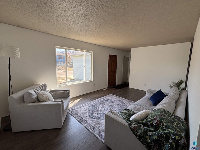 living room with a textured ceiling and dark wood-style floors