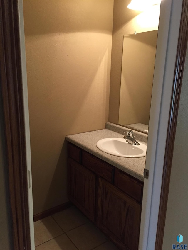 half bath with tile patterned flooring and vanity