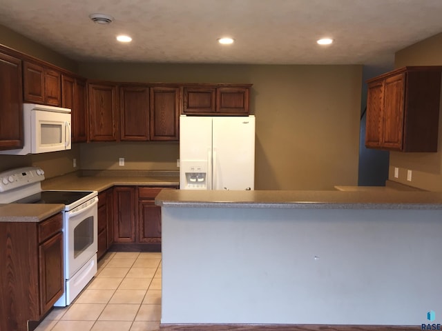 kitchen featuring white appliances, light tile patterned floors, a peninsula, and recessed lighting