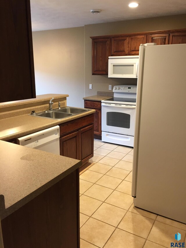 kitchen featuring a sink, white appliances, light tile patterned flooring, and recessed lighting