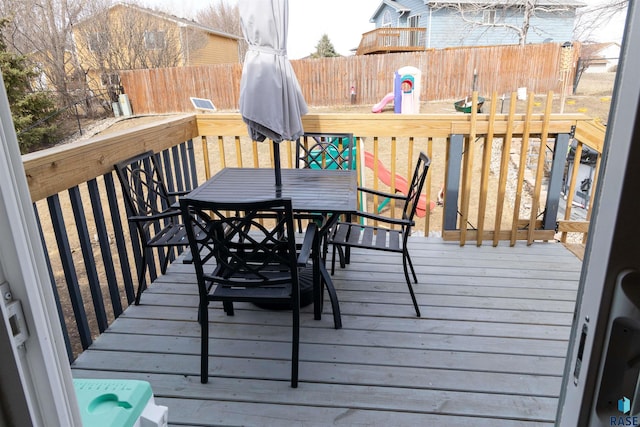 deck with outdoor dining space and a fenced backyard