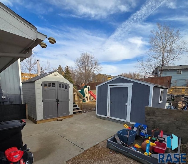 view of shed featuring a playground and fence