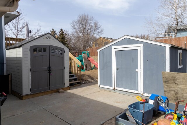 view of shed featuring a playground and fence