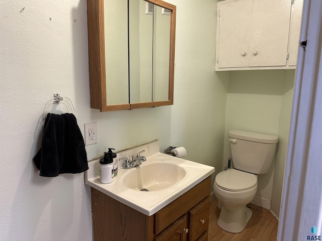 bathroom with vanity, toilet, and wood finished floors