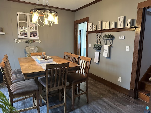 dining area featuring dark wood-type flooring, a notable chandelier, baseboards, and ornamental molding