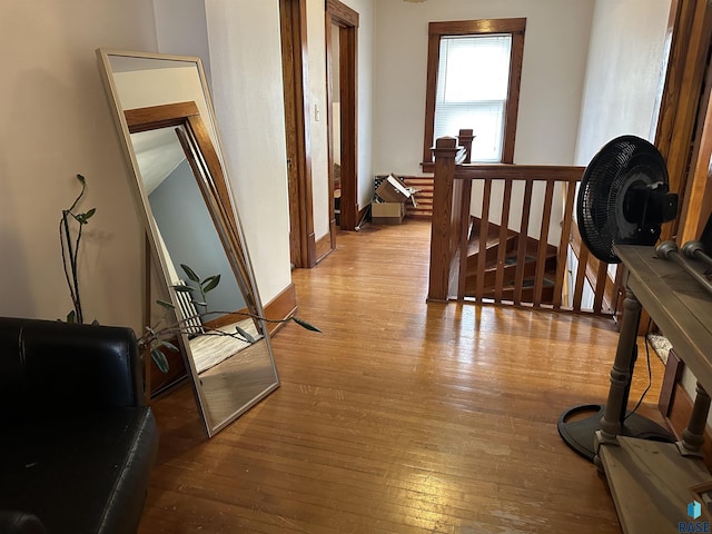 hallway with an upstairs landing and light wood-type flooring