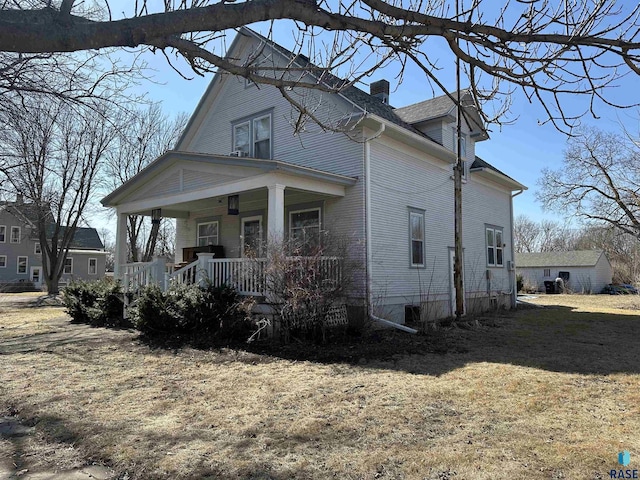 exterior space with covered porch and a chimney