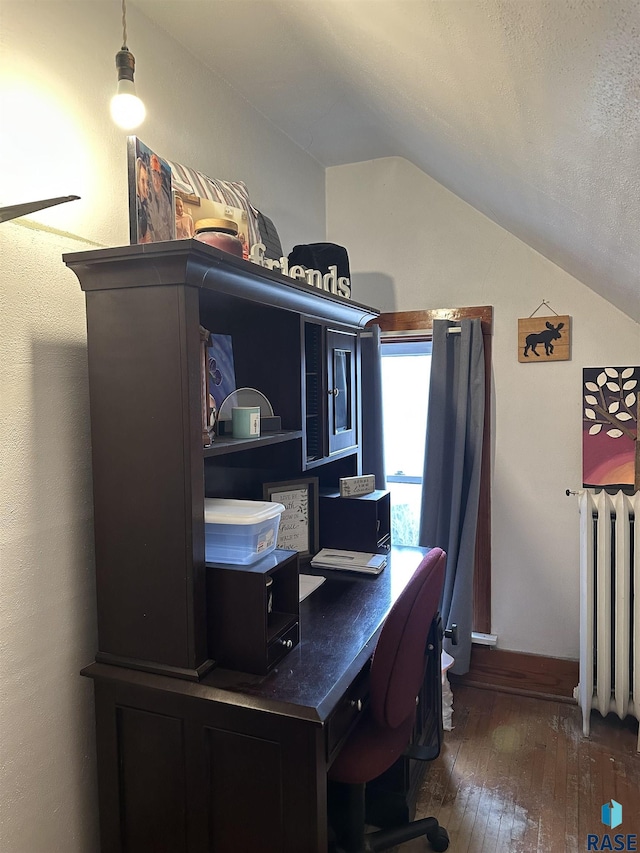 office space with hardwood / wood-style flooring, radiator heating unit, baseboards, and vaulted ceiling