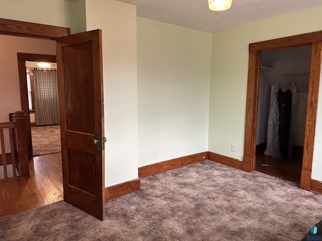 unfurnished bedroom with a spacious closet, baseboards, and carpet floors