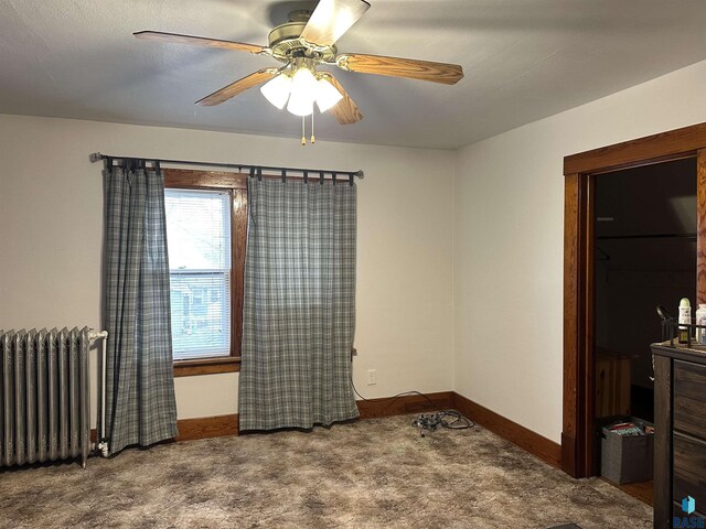 carpeted bedroom featuring radiator heating unit, baseboards, and ceiling fan