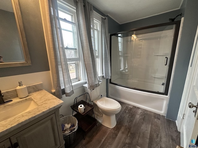 full bath featuring vanity, toilet, wood finished floors, and enclosed tub / shower combo