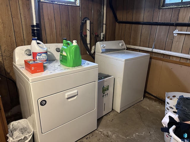 laundry area with washer and dryer, wooden walls, and laundry area