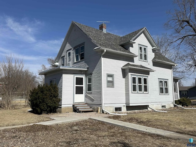 view of front of property with entry steps and a chimney