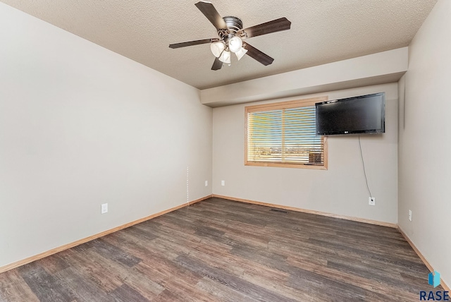 empty room with a ceiling fan, visible vents, wood finished floors, baseboards, and a textured ceiling