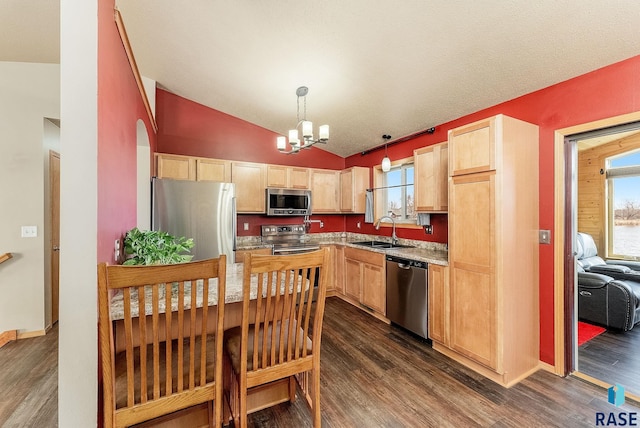 kitchen with a sink, light brown cabinets, a chandelier, and stainless steel appliances