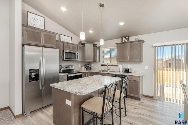 kitchen with a sink, a kitchen island, stainless steel appliances, lofted ceiling, and dark brown cabinets