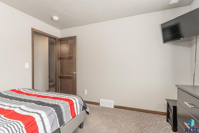 bedroom featuring visible vents, baseboards, and carpet