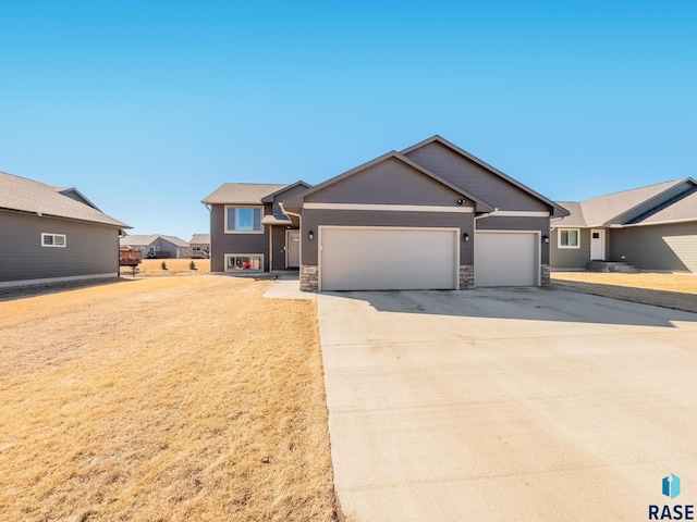 single story home featuring an attached garage, stone siding, and driveway