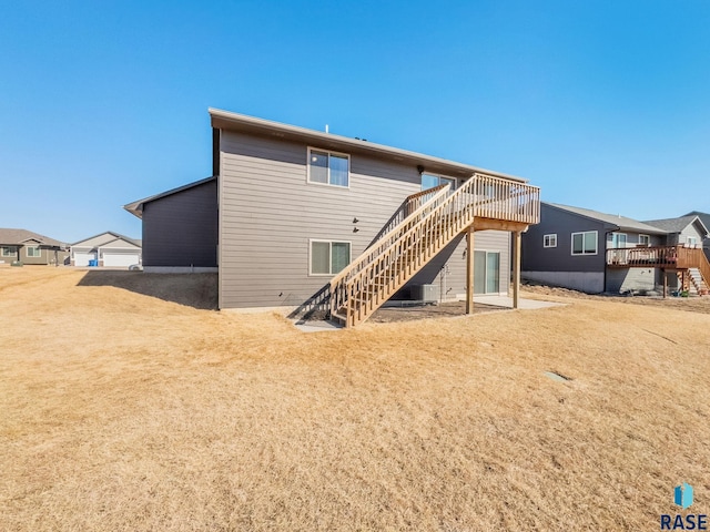 rear view of house with a wooden deck and stairs