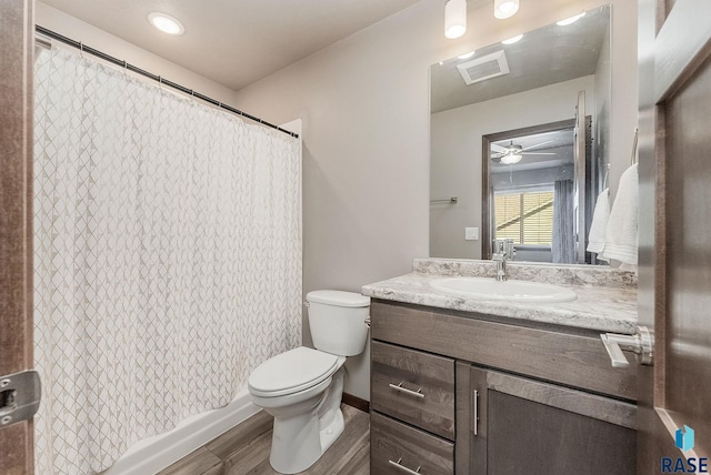 bathroom with visible vents, ceiling fan, toilet, wood finished floors, and vanity