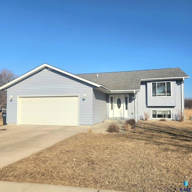 view of front of house with an attached garage, driveway, and roof with shingles