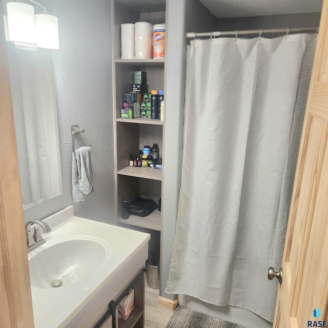 bathroom featuring vanity and a textured wall