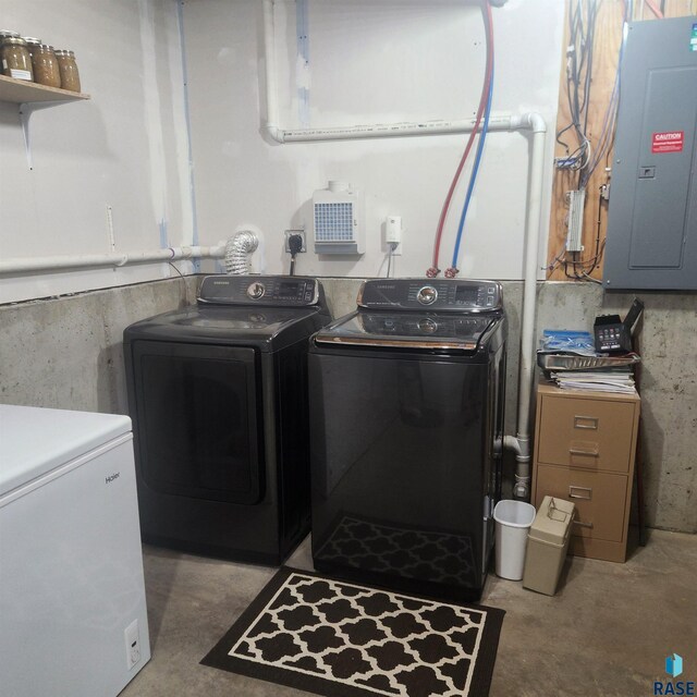 washroom featuring laundry area, electric panel, and separate washer and dryer