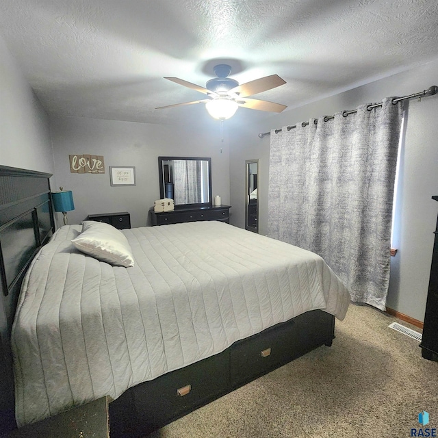 bedroom featuring visible vents, ceiling fan, a textured ceiling, and carpet