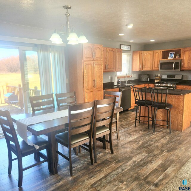 dining area featuring dark wood-style floors, recessed lighting, a textured ceiling, and an inviting chandelier