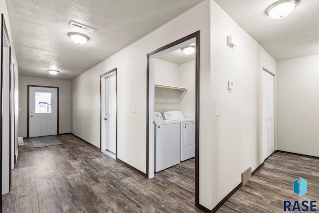 foyer entrance with dark wood finished floors, a textured ceiling, visible vents, and washing machine and clothes dryer
