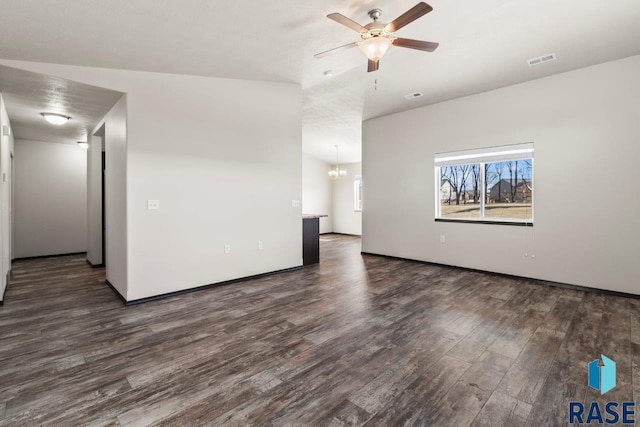 empty room featuring visible vents, wood finished floors, and ceiling fan with notable chandelier
