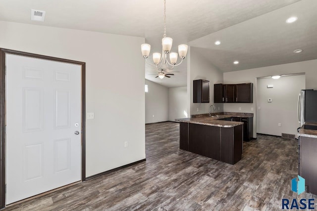 kitchen with visible vents, dark wood finished floors, dark brown cabinetry, fridge, and ceiling fan with notable chandelier