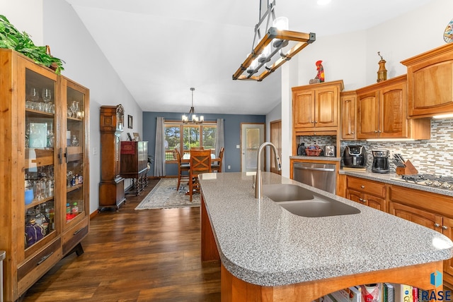 kitchen featuring a sink, decorative backsplash, vaulted ceiling, stainless steel appliances, and a chandelier