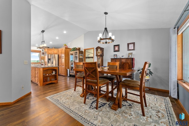 dining area with baseboards, dark wood-type flooring, an inviting chandelier, and vaulted ceiling