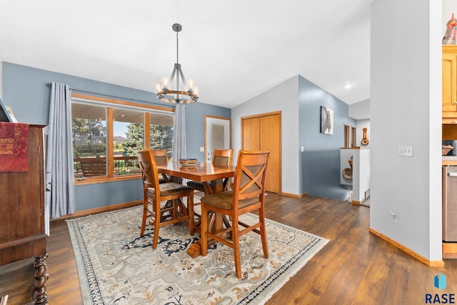 dining room featuring a notable chandelier, wood finished floors, baseboards, and vaulted ceiling