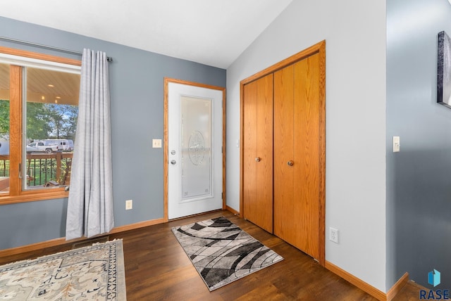 foyer entrance with baseboards, wood finished floors, and vaulted ceiling