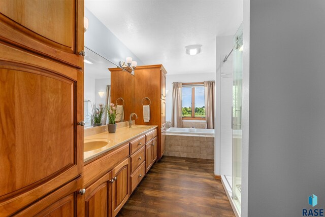 bathroom featuring a shower stall, a garden tub, wood finished floors, and a sink
