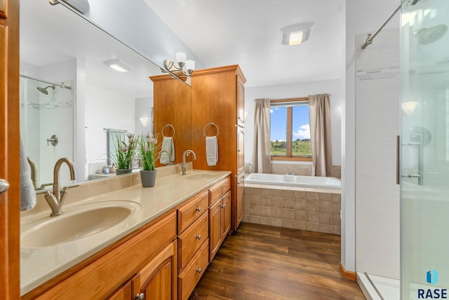 bathroom with a sink, wood finished floors, and a stall shower