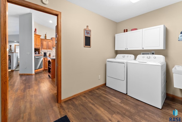 clothes washing area with baseboards, cabinet space, separate washer and dryer, and dark wood-type flooring