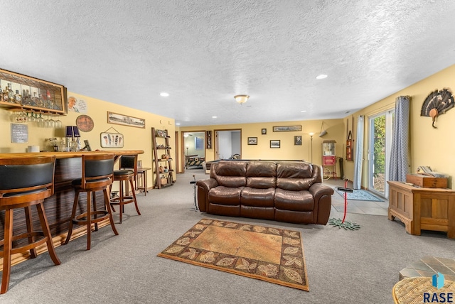 carpeted living room with a bar, recessed lighting, and a textured ceiling