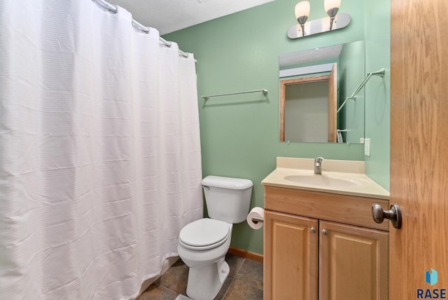 bathroom with tile patterned flooring, toilet, vanity, and baseboards