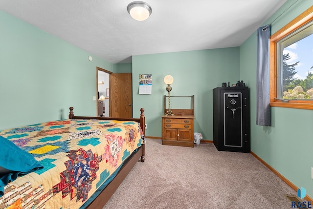 bedroom with light colored carpet and baseboards