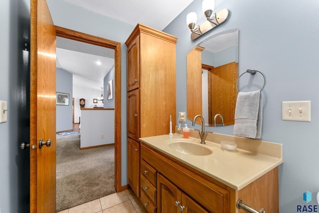 bathroom with vanity, baseboards, and tile patterned flooring