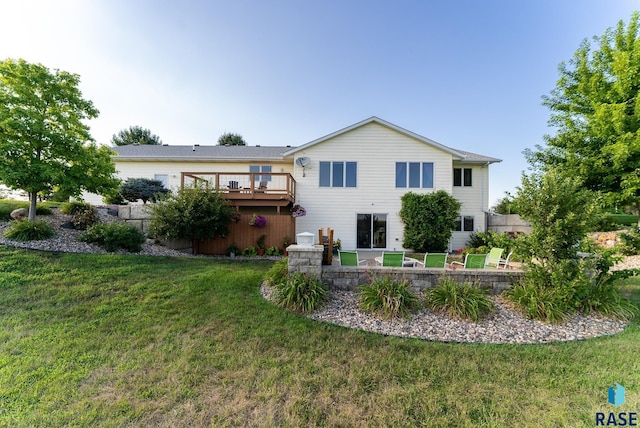 back of property featuring a wooden deck and a yard